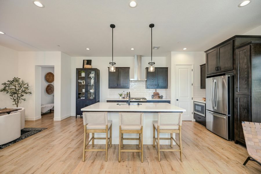 A modern open-plan kitchen with dark wood cabinets and a large white island, designed to organize your kitchen with style.