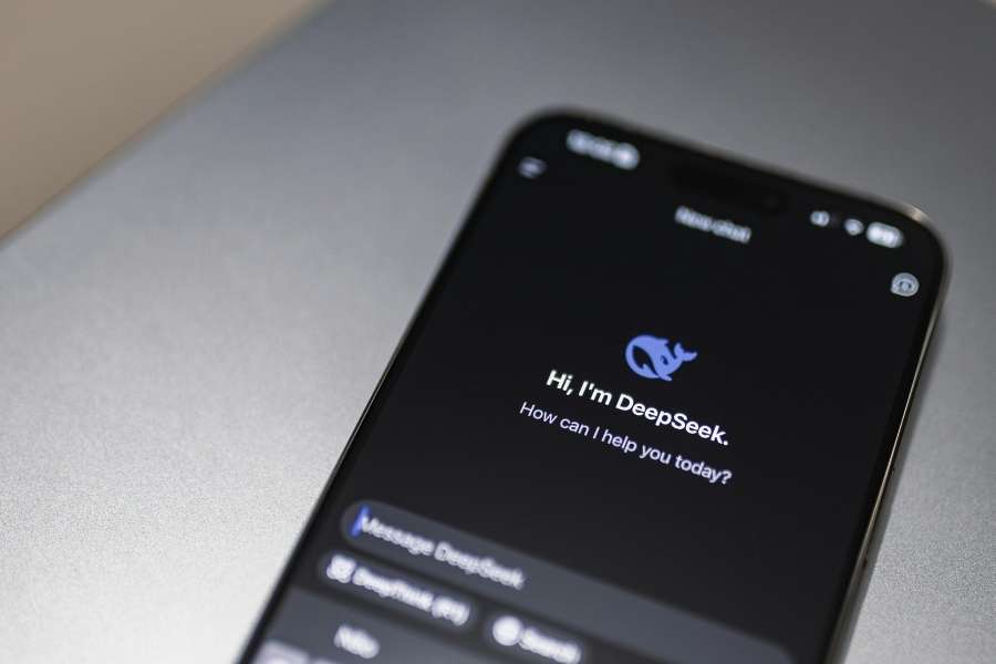 A smartphone screen displays the ChatGPT interface with the official OpenAI logo and text reading 'Hi, I'm ChatGPT. How can I help you today?'.