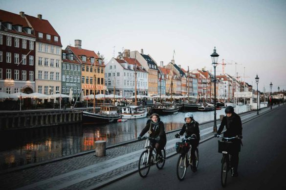 Cyclists ride along the canal waterfront as they explore Copenhagen beyond the main sig